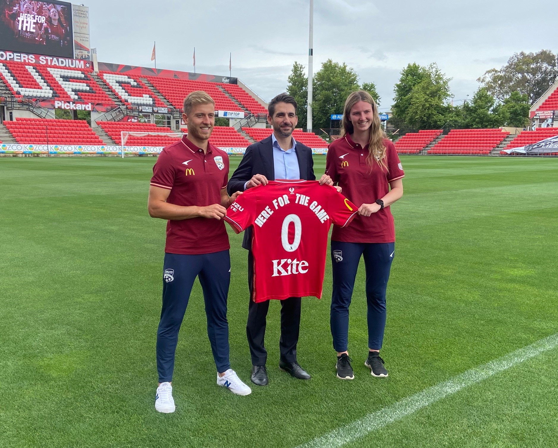 AUFC CEO and players holding up AUFC jersey